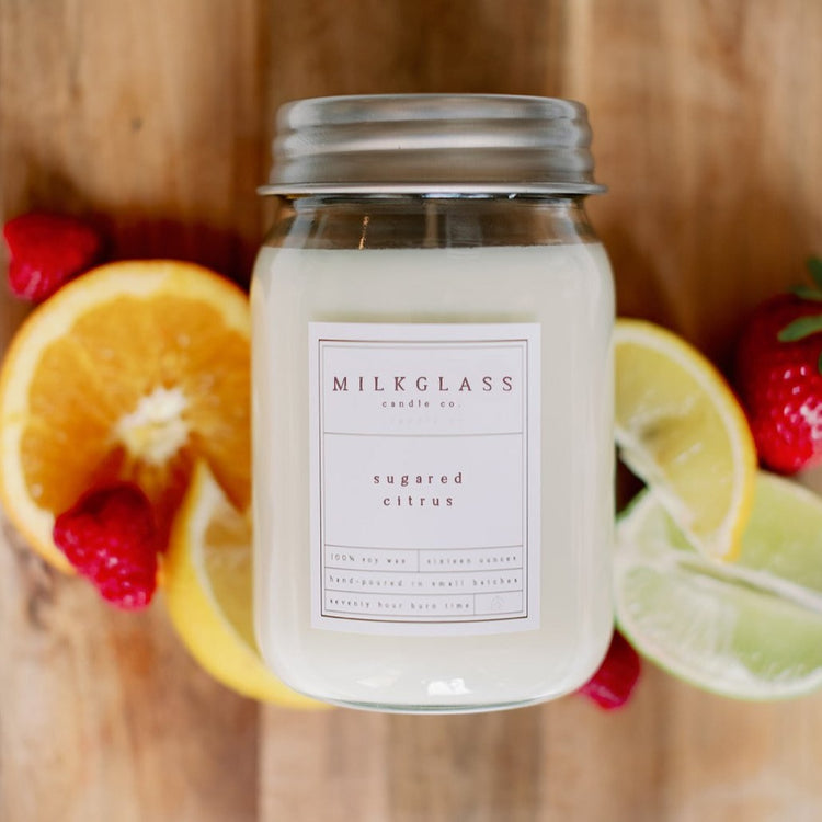 MILKGLASS candle co hand poured sugared citrus candle in glass jar with citrus fruits background